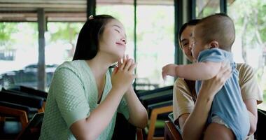 Footage of handheld shot, Two happy women having fun playing with a little boy in a coffee shop. Family enjoying time together. Happy lifestyle. video