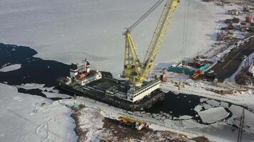 Drone view of a floating crane standing among the ice of the sea channel video
