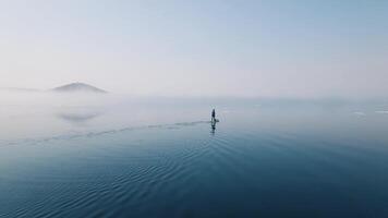 Drone view of a sup surfer floats through the ice capturing serenity. video