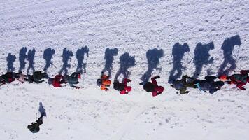 Top down view of a large group of climbers climbing up a snowy slope video