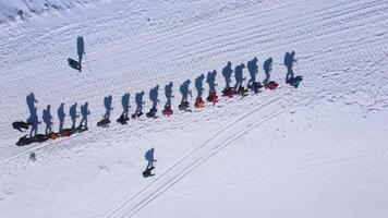 Top down view of a large group of climbers climbing up a snowy slope video