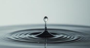 Water droplet creates ripples on a calm surface in a serene environment photo
