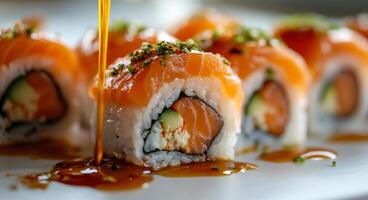 Fresh sushi rolls with salmon and sesame drizzled with sauce on a plate photo