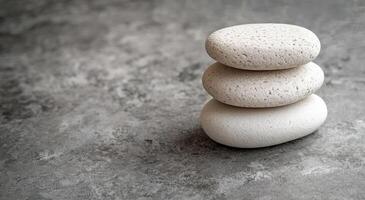 Stacked smooth stones on a gray surface creating a tranquil and balanced arrangement photo