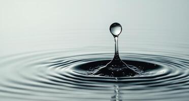 Water droplet creates ripples on a calm surface in a serene environment photo