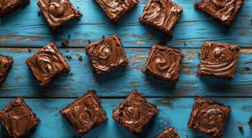 Delicious homemade brownies arranged on a rustic blue wooden table in afternoon light photo
