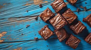 Delicious homemade brownies arranged on a rustic blue wooden table in afternoon light photo