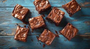 Delicious homemade brownies arranged on a rustic blue wooden table in afternoon light photo