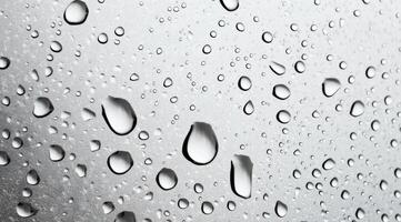 Close-up of raindrops on a glass surface during a rainy afternoon in a quiet urban setting photo