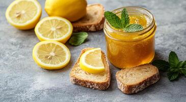 Homemade lemon preserves with fresh mint displayed alongside sliced lemons and bread photo
