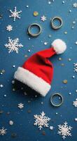 Festive red Santa hat surrounded by snowflakes and golden rings on blue background photo