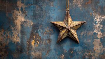 A rustic five-pointed star ornament hanging against a weathered blue wall background photo