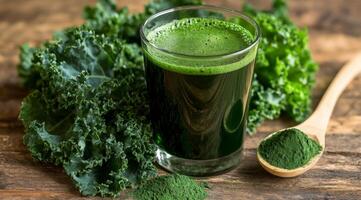 Fresh green smoothie served in a glass with kale and spirulina on a wooden table photo