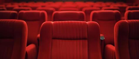 Empty red theater seats await moviegoers in a dimly lit cinema setting photo