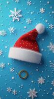Decorative Christmas hat and golden ring surrounded by snowflakes on a blue background photo