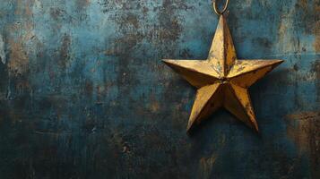 A rustic five-pointed star ornament hanging against a weathered blue wall background photo