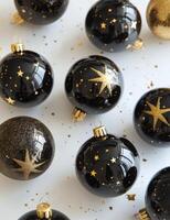 Elegant black and gold ornaments hanging from a white Christmas tree photo
