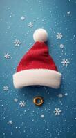 Decorative Christmas hat and golden ring surrounded by snowflakes on a blue background photo