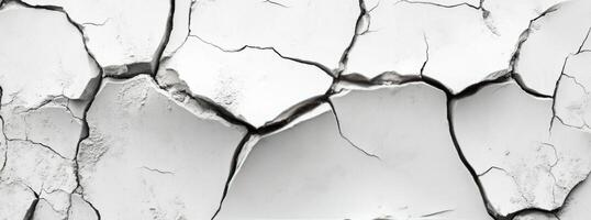 Cracked surface revealing texture and patterns on a dry, white wall in bright daylight photo