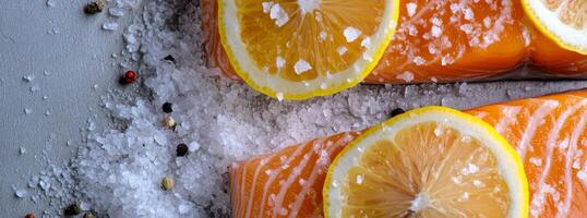 Fresh salmon fillet with lemon slices and coarse salt on a rustic wooden background photo