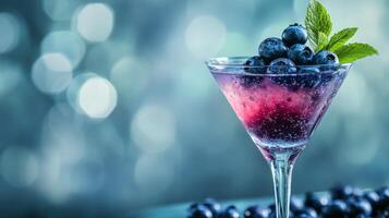 Refreshing berry cocktail garnished with mint and blueberries on a colorful blurred background photo