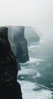 brumoso acantilados y estrellarse olas a lo largo el escabroso costa a acantilados de Moher en Irlanda foto