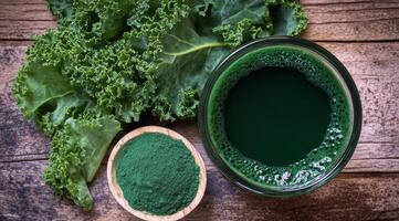 Fresh green smoothie served in a glass with kale and spirulina on a wooden table photo