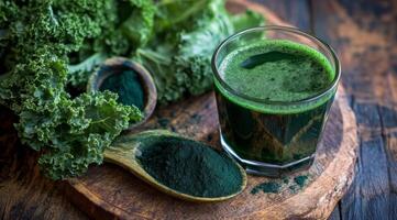 Fresh green smoothie served in a glass with kale and spirulina on a wooden table photo