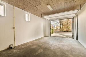 An empty garage with a door and a window photo