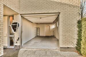 A garage with a door open and a car in it photo