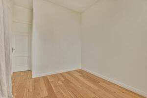 An empty room with white walls and wooden floors photo