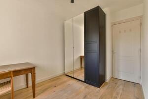 A room with a desk and a black cabinet photo