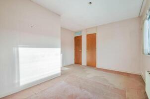An empty room with a door and a window photo