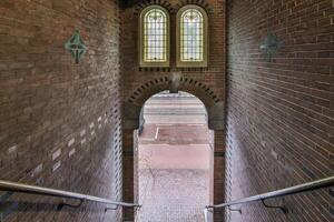 A stairway leading to a brick building with two windows photo