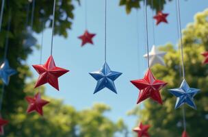 Colorful hanging stars in red, white, and blue against a bright blue sky at a festive outdoor event photo