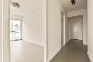 A hallway with white walls and a door photo