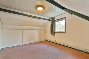 An empty room with a window and a closet photo