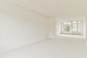 An empty room with white walls and a large window photo