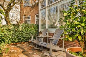 A brick patio with a bench and a tree photo