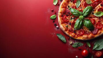 Delicious homemade pizza topped with fresh basil, tomatoes, and olives on a red background photo