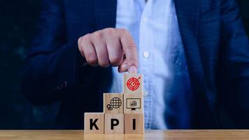 KPI text in wooden cube, Key Performance Indicator concept, Management data System KPI connected database follow earnings, Financial business data analytics graph dashboard. photo