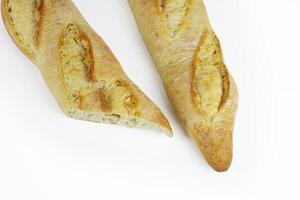 Two freshly baked baguettes loaves. Rustic French baguette with a crispy golden crust. Traditional artisan homemade white bread. Close up. Isolated on white background. With clipping path. Copy space photo