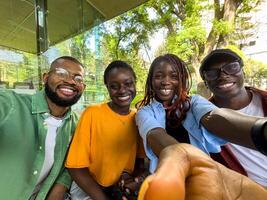 Four black student friends take selfie take break from studying while sit outside university library photo