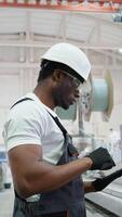 Worker Engineer With Tablet On Factory Analyzes The Production Process. Vertical video