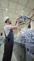 Worker On Factory Analyzes The Production Process And Programming Industrial CNC Machine Tool. Vertical video