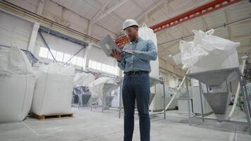 Industrial engineer programmer checking the production line with laptop at windows factory. Factory for aluminum and PVC windows and doors production video