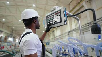Black operator working at programmable CNC machine in factory industries video