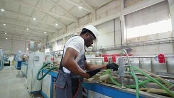 African engineer in uniform with tablet checks the cooling system at the factory video