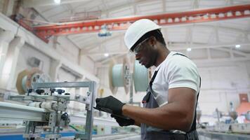 PVC factory worker engineer is using a tablet with an engineering software on production line video