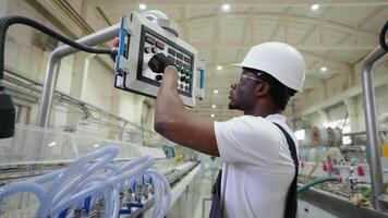 African engineer working at programmable CNC machine in factory industries video
